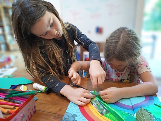 2 children creating an animation background with paper cut-outs and crafts